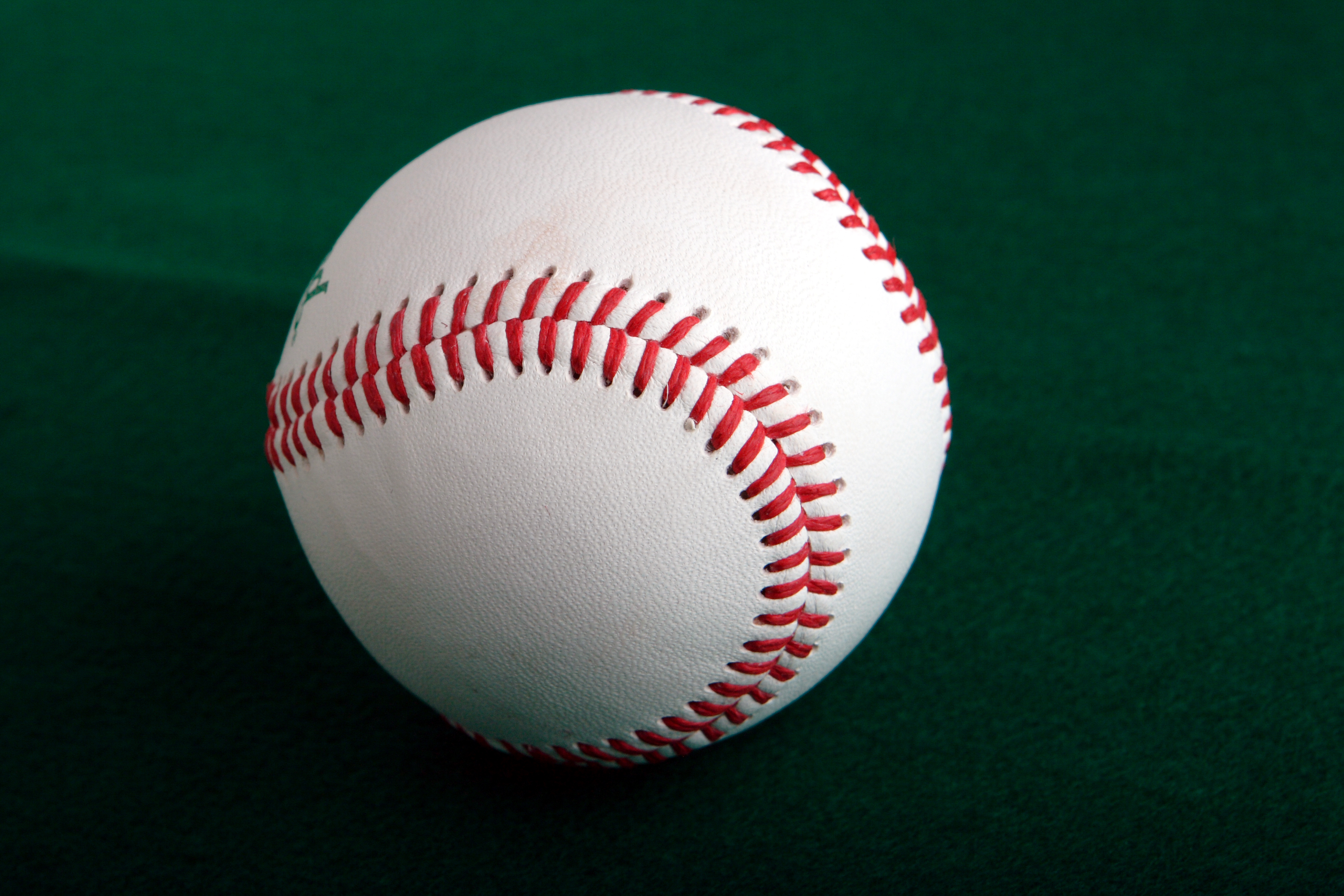 Pelota de béisbol sobre fondo verde