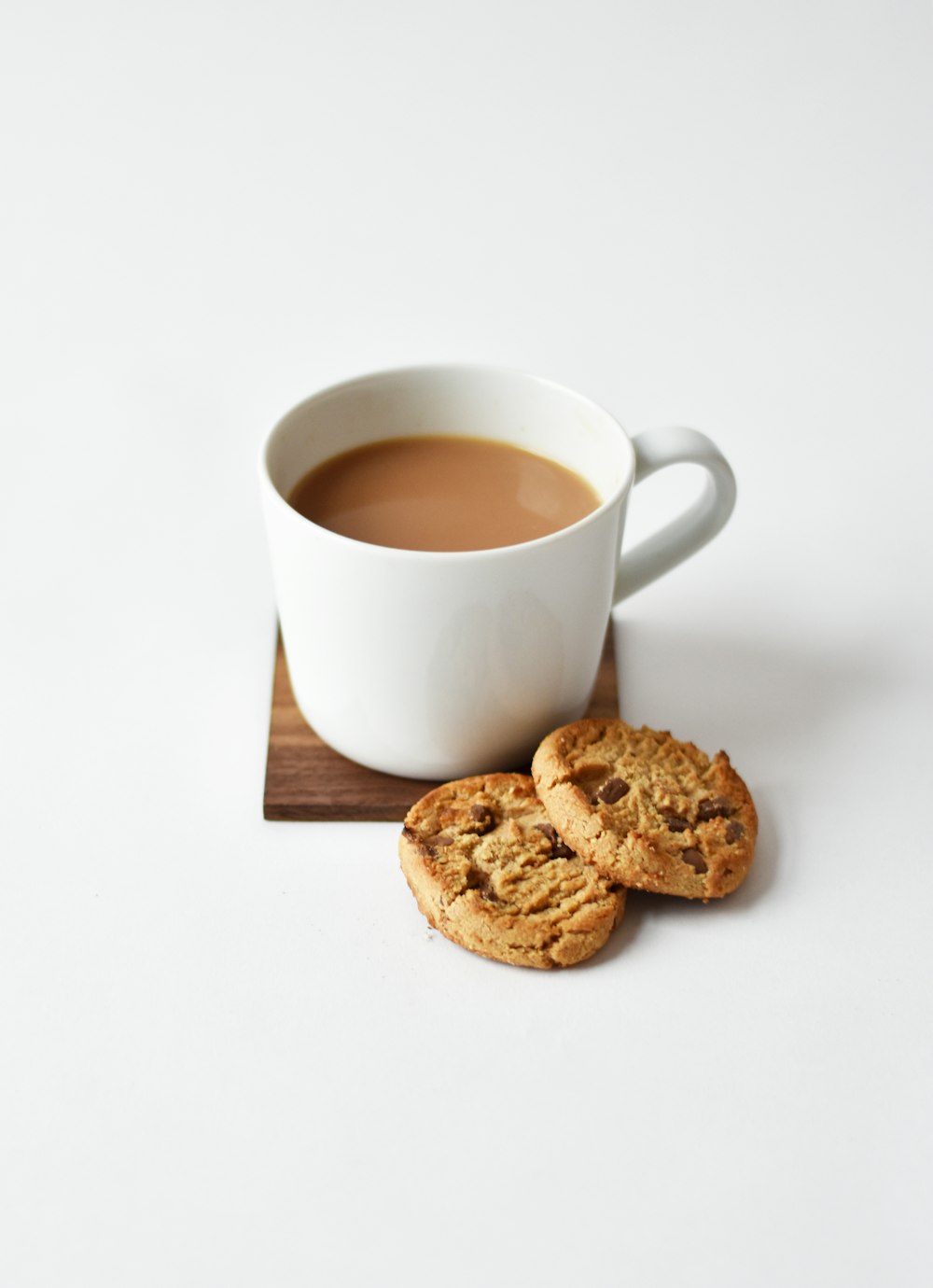 A cup of chai served with rusks and cookies